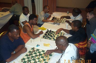 FM Stephen Muhammad (right center) showing GM Maurice Ashley his game against IM Eugene Perelshteyn. Copyright  2002, Daaim Shabazz.