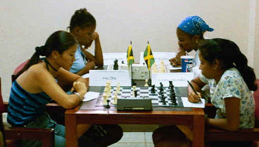 Foreground: Zhu Hui vs. Keisha Ramator. Background: Deborah Richards vs. Natalee Gooden. Copyright  2002, Jamaica Ambassadors Chess Academy. 