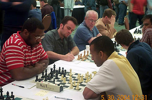 FM Norman Rogers and IM-elect Stephen Muhammad face off in 4th round battle. Muhammad won a wild encounter despite of his king getting stuck in the center. Copyright  2004, Daaim Shabazz