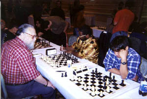 NM Jerry Hanken vs. NM Pete Rogers. Daniel Fernandez ponders his move on the adjacent board. Copyright © Daaim Shabazz, 2002.
