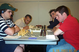 Finale! Boards 1-2: Richard Francisco vs. Carlos Perdomo (0-1) - foreground; Stephen Muhammad vs. Rashid Ziatdinov (½). Copyright © 2003, Daaim Shabazz