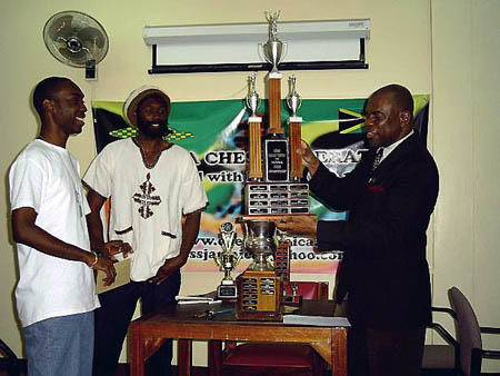 Jamaican President Ian Wilkinson (right) prepares to present FM Warren Elliott (left) with the Championship trophy while Negash Bezaleel looks on. Copyright  2004, Mark Bowen