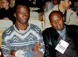 Felix Malata (ZIM), Captain of the Women's Team (wearing a sweater) and David Zulu (ZAM) Captain of the Men's Team (wearing a leather jacket). Copyright  Jerry Bibuld, 2002.