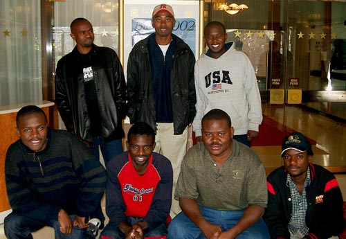 Zambia's Mens Team. (kneeling, from left to right) IM Amon Simutowe (Bd. 1), Stanley Chumfwa (Bd. 2), FM Nase Lungu (Bd 3) and Tizenge Mbambara (Bd. 4); standing, from left to right, are Gershom Muzende (Bd. 5), Malupande Lungu (Bd. 6) and David Zulu (captain). Copyright  Jerry Bibuld, 2002.