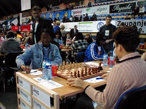 Barbados’ Rashaana Blenman (seated left) faces Angola’s Flora Alfonso. She qualified for her FIDE rating and scored 7½-5½. Copyright © 2002 Barbados Chess Federation.