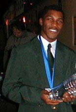 IM Robert Gwaze holding trophy after winning Olympiad gold medal. Copyright  2002 Barbados Chess Federation.