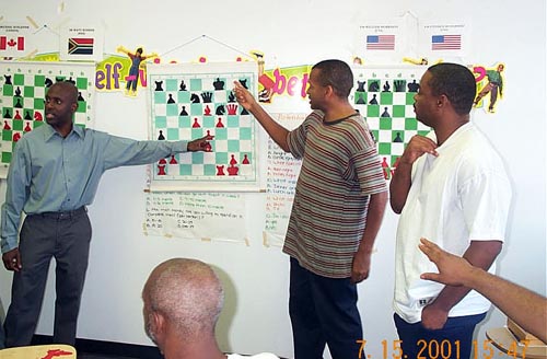 NM Jerald Times analyzes position with FM Stephen Muhammad at the Wilbert Paige Memorial tournament in July 2001. FM William The Exterminator Morrison looks on with the rest of the audience. Copyright  2001, Daaim Shabazz.