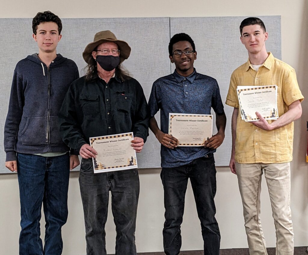 Tournament Director Jacob Sperber with section winners of Capital City Open III. Richard Kennedy (Open), Caleb Parker (under-1400), and Jacob Taylor (under-1000). Photo by Claudia Sperber