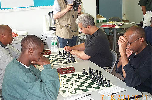 Kobese playing Colding while Nsubuga wrestles Schleifer.