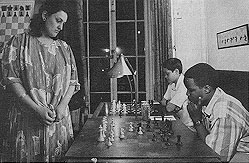 Above is K.K. Karanja (seated) playing GM Maya Chiburdanidze in a simultaneous exhibition at the Marshall Chess Club in 1987. At the time, Maya was the Women's World Champion. Photograph by Nigel Eddis.