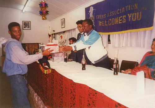 Pedro receives his prize for winning the 1993 Africa Junior Chess Championship from the late Chairman of Kenya Chess Association Tom Sagwe while Vice-Chairman Francis Rodrigues looks on. The event was held at the YMCA in Nairobi, Kenya and ran from 11th to 26th December 1993. Photo credit Kim Bhari.