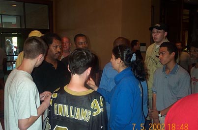 Shirley Ben-Dak explaining situation to Bruce Thompson while crowd looks on. Copyright © 2002, Daaim Shabazz.
