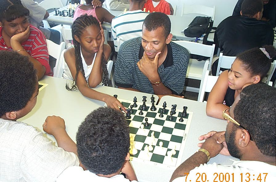 Chess student makes move under watchful eye of FM Stephen Muhammad. Copyright © 2001, Daaim Shabazz.