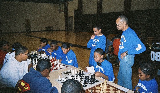 Detroit Duffield Coach Glenn Smith (standing right) and Team Manager Jeremy Futrell watch as their team plays a match.