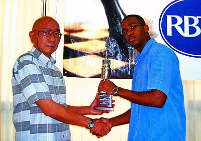 Brandon Wilson (right) is presented with the Shane Matthews Junior Champion Trophy by International Chess Arbiter Serafin Chuit Perez of Cuba. Chuit Perez is in Jamaica conducting International Chess Arbiter seminars. Copyright   2006, Daaim Shabazz.