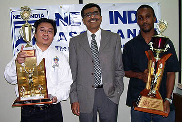 Elton Joseph (far left) being presented his Heroes Cup while Tameko McDonald and Donovan Williamson flash their trophies. Dr. Harold Munnings (2nd from left)  sponsored the tournament. Photo by Bahamas Chess Federation.