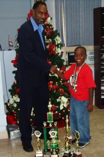 Mr Andre LeVeau and R.J with a collection of his trophies.