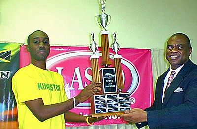 FM Warren Elliott (left) accepts the LASCO National Chess Champion Trophy from JCF President Ian Wilkinson in this file photo. Photo by Jamaican Chess Federation.