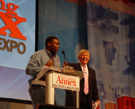 Orrin Hudson tells the Donald Trump story in front of 40,000 attendees at the Real Estate and Wealth Expo in Atlanta. Trump seems to be enjoying the rendition. Photo courtesy of BeSomeone, Inc.