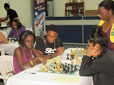 Corine Howard and Adita Soondarsingh analyse their 18-move game with Krishna Gray watching. All three had short draws with the other two.