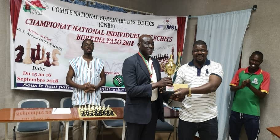 Clément Gissou receiving 1st place trophy from Director General of Sport/Leisure, Mr. Vohoun Tamimi. Photo by Burkanibe Chess Federation