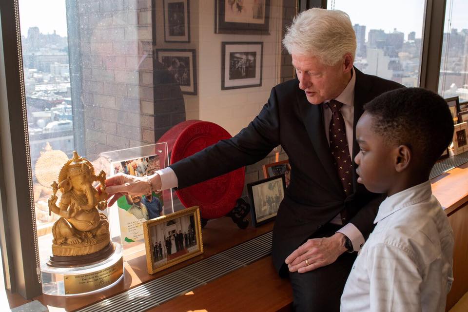 42nd U.S. President Bill Clinton showing Tani a depiction of Ganesh, the Hindu God who is the remover of obstacles. Photo by Nicholas Kristof.