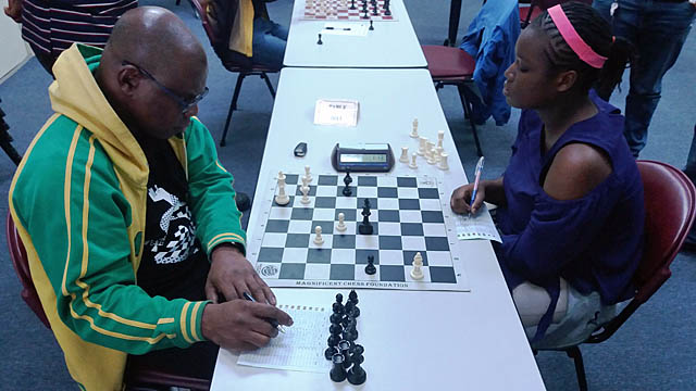Incumbent President Ian Wilkinson QC (left) plays the final moves of his game against National Junior Girls Champion Raehanna Brown. Photo by David Rose/Jamaica Chess Federation.