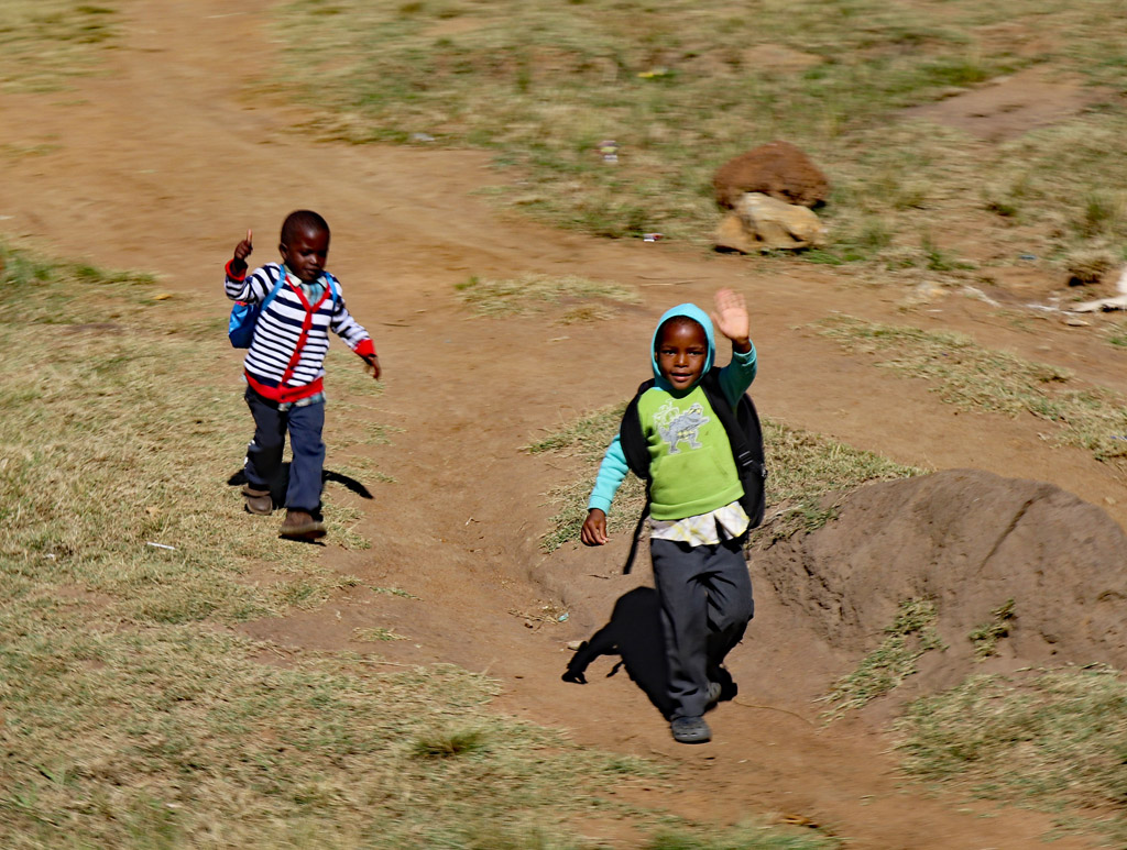 Boys chased down the bus to wave at tourists. Photo by Daaim Shabazz.