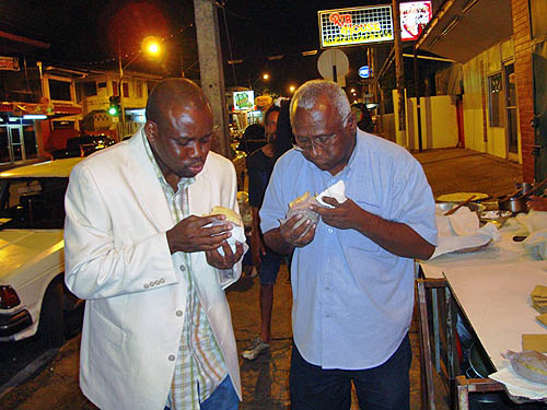 Nigerian IM Oladapo Adu (Left) enjoys a Roti an East Indian culinary delight with Carlyle Singh of the Trinidad and Tobago Chess Foundation.