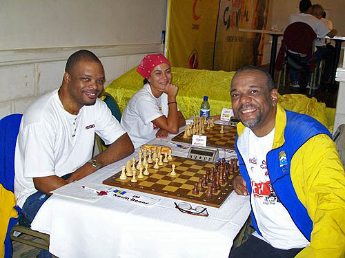 Classic Photo: IM Kevin Denny battles FM Philip Corbin in the last round of the Caribbean Chess Carnival. WGM Ilaha Kadimova of Azerbaijan delights in the moment. Photo by FM Philip Corbin.