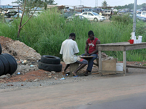 Men playing checkers. Still no sign of chess in Ghana.