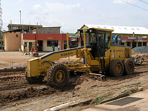 Earth movers leveling the muddy roads which had become impassable. The vehicle in which I was riding got stuck.