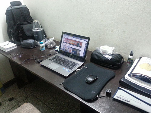 My workstation for two weeks... laptop, blender, travel iron, herbal supplements, dried fruits and bug repellent.