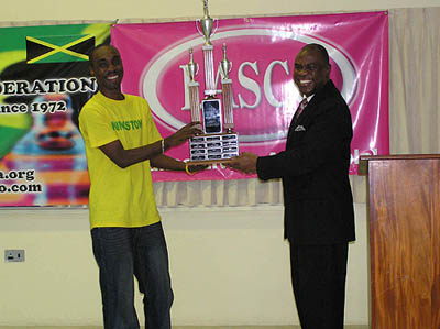 Jamaican Federation President Ian Wilkinson presents championship trophy to FM Warren Elliott as Jamaican National Champion.