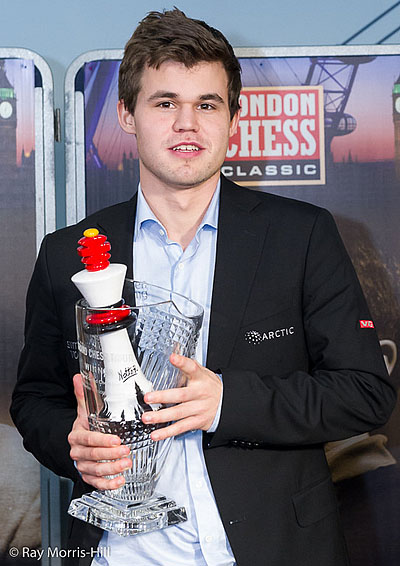 Magnus Carlsen receiving both Grand Chess Tour Cup and London Chess trophy. Photo by Ray Morris-Hill.