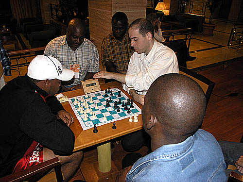 Meanwhile, Pedro Aderito of Angola was blitzing with a Latin American player. The three Angolans watching are Manuel Mateus (light shirt), Eugenio Campos (yellow shirt) and Catarino Domingos (blue jacket).