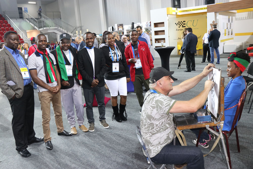 Malawians in Batumi, Georgia watching teammate Desiderata Nkhoma
get a sketch done by Temur Dadiani. Photo by Daaim Shabazz