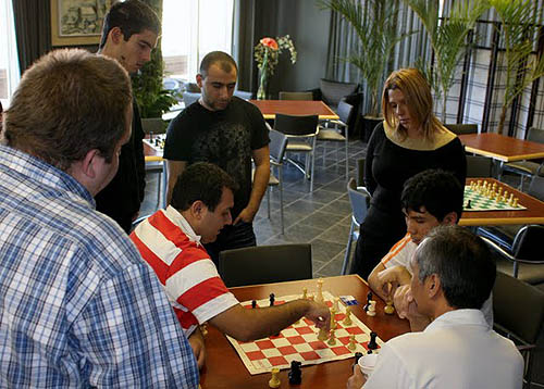 GM Susan Polgar watching Rauf Mamedov and Wesley So analyze while  Gabor Papp and Varuzhan Akobian also kibitz.