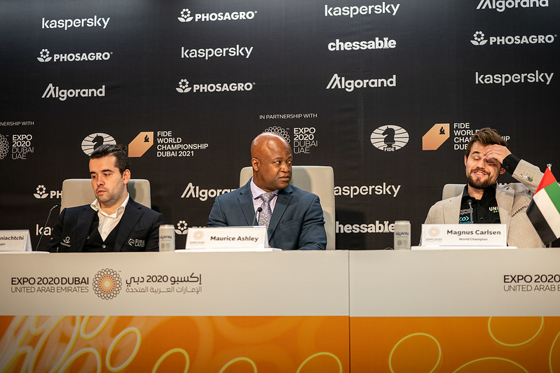 Carlsen explaining the moment during the press conference. Ian Nepomniachtchi and Maurice Ashley at the dais. Photo by Niki Riga/FIDE