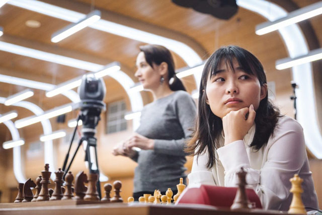 Ju Wenjun preparing while Kateryna Lagno lurks in the shadows. Photo by ugra2018.fide.com.