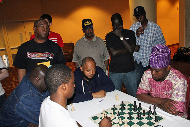 Odafe (right) playing Zimbabwe's Farai Mandizha in blitz at 2015 World Open. Members of St. Nicholas Chess Club (Brooklyn, NY) look on.