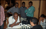 Okechukwu Iwu, Adekunle Ogunmefun, and Paul Obiamiwe watch "Toks" play a round of blitz. Frank Johnson (wearing the black kufi) also observes.